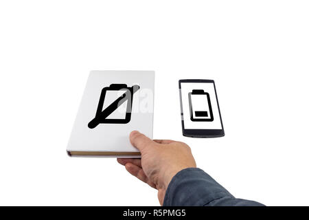 Hand taking a book instead of phone. New versus old concept. Low battery problem. Stock Photo