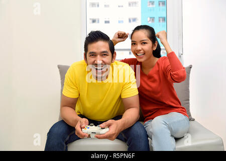 Joyful Asian Boyfriend And Girlfriend Playing Video Game At Home