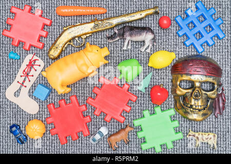 lot of various multicolored toys laid out on a gray carpet, top view, close-up Stock Photo