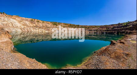 Panoramic view from the bottom of a crater filled with water. Stock Photo