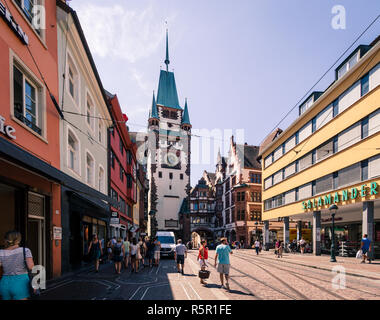 Freiburg im Breisgau, Baden-Wurttemberg, Germany - JULY 30 2018 : people strolling in shoppingstreet towards Martin's Gate (Martinstor) in summer Stock Photo