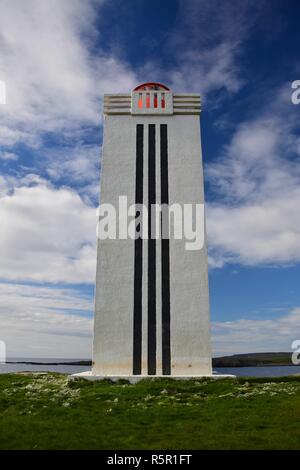 The lighthouse at Kalfshamarsvik on peninsula Skagi in Iceland. A white tower with three black stripes. Stock Photo