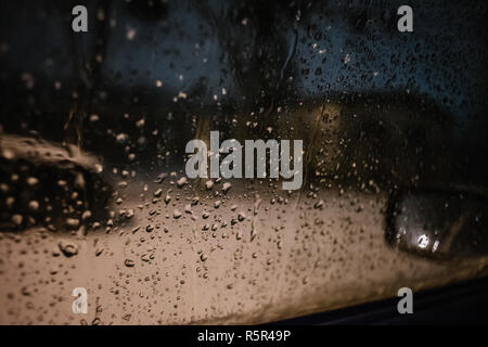 Water drops on car side glass in dusk Stock Photo