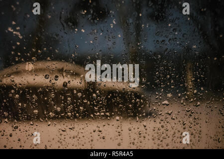 Water drops on car side glass in dusk Stock Photo