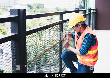 Inspector use measuring tape to measure balcony after renovation building. Stock Photo