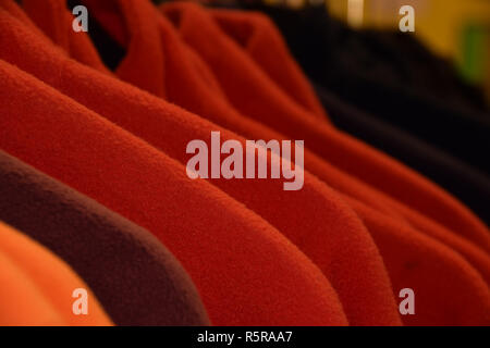 small part of colorful fleece jackets on hanger, colorful polar fleece jackets on a hanger macro shot made of recycled plastic bottles Stock Photo
