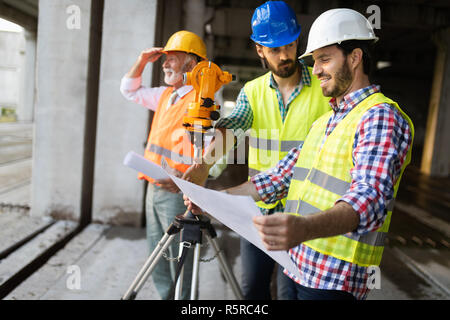 Engineer, foreman and worker discussing in building construction site Stock Photo