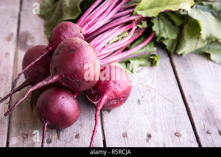 Red Beetroot with herbage green leaves on rustic background. Organic Beetroot Stock Photo