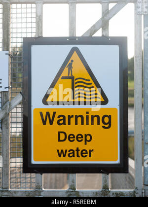 close up yellow sign at dock warning deep water Stock Photo