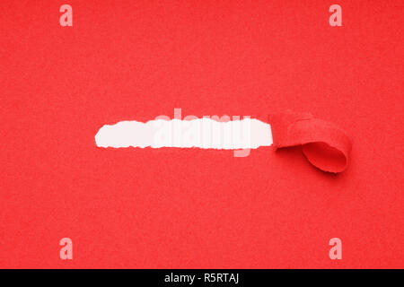 peel away ripped red paper to reveal hidden copy space underneath Stock Photo