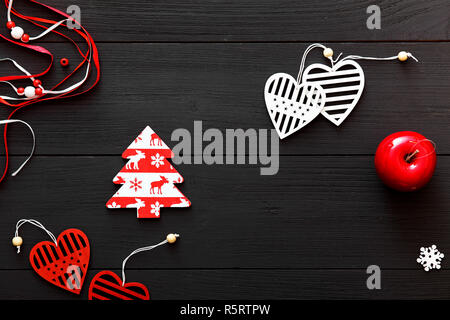 Xmas decoration red and white Christmas tree, hearts toys, happy new 2018 year decoration on black wooden background table, winter holidays celebratio