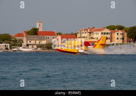 Sibenik, Croatia - August 05 2012: Water bomber n action fighting fires near Sibenik. Croatia's coast is plagued by wildfires in summer and operates a Stock Photo