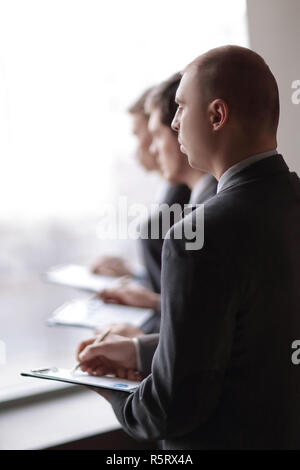 image of a businessman being at the conference and making notes on the foreground Stock Photo
