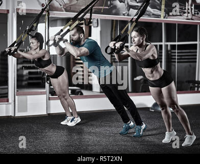 Athletic people doing crossfit training with trx straps Stock Photo