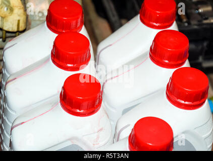 White plastic cans with red lids. Cans of transmission oil Stock Photo