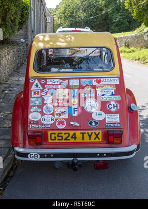 Red and yellow Citroen 2 CV6 Special covered in travel stickers Stock Photo