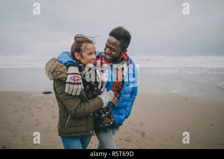 Young Couple Walk Along Winter Beach Stock Photo