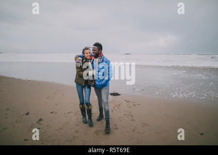 Young Couple Take Romantic Walk On A Winter Beach Stock Photo