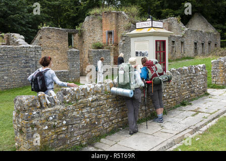 Backpackers exploring the famous 'ghost village' of Tyneham, a village that was deserted in 1943 for military training on the Isle of Purbeck, Dorset Stock Photo