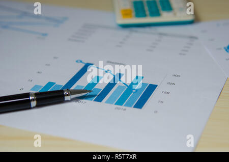 Financial graphs analysis and pen. Stock Photo