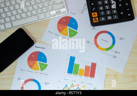 business documents  Financial graphs analysis and keyboard with smart phone on desk. Stock Photo