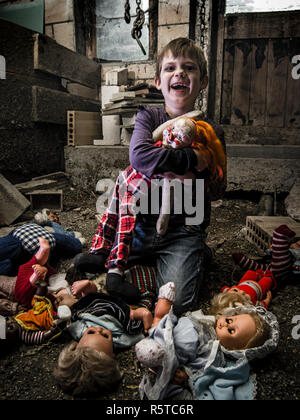 Creepy boy and scary clown doll in the barn Stock Photo