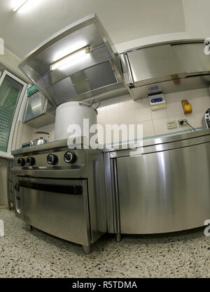 giant aluminum pot above the gas stove in the large industrial kitchen with steel stoves Stock Photo