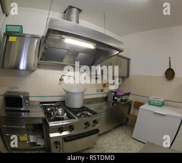 large industrial kitchen with steel stoves and a giant aluminum pot above the gas stove Stock Photo