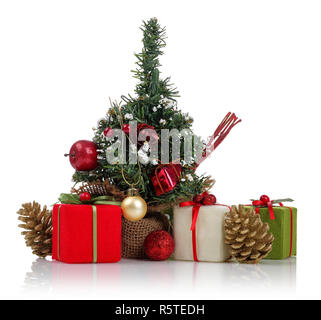 Mini Christmas tree with gifts, pine cones and ornaments isolated on white background Stock Photo