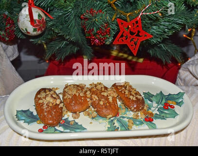 traditional greek melomakarona in front of the Christmas tree - cookies with honey and nuts Stock Photo