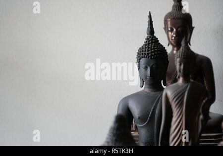select focus of vintage black ancient buddhas statue in the middle of other buddhas statue Stock Photo