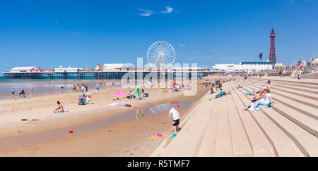 Blackpool uk people on the sandy beach Blackpool beach summer with Blackpool tower and central pier Blackpool Lancashire England UK GB Europ Stock Photo