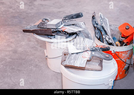 Finishing tools. Brush paint and steel plate spatula used for putty and paint on the floor. Stock Photo