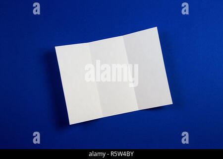 Mockup of blank white tri fold booklet brochure on blue background Stock Photo