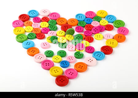 Heart shaped of colorful sewing buttons on white Stock Photo