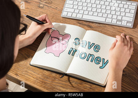 Woman Writing On Checker Note Book Stock Photo