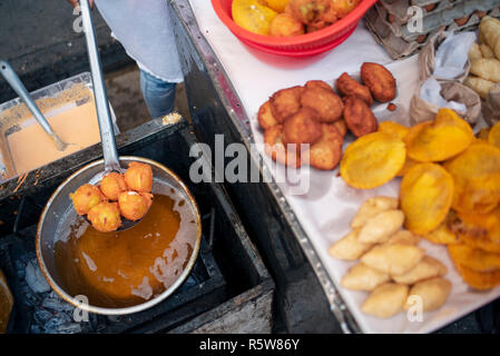 Fried street food in the making. Yuca, potato, patacones with costeño (plantains with soft cheese) and arepa with egg. Cartagena de Indias, Colombia Stock Photo