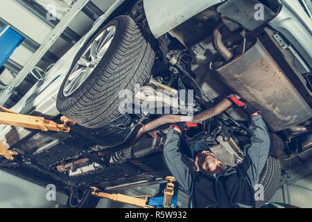 Automotive Mechanic Job. Caucasian Auto Service Worker and the Vehicle Maintenance. Stock Photo