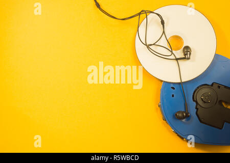 Cd player and compact disc with earphones on yellow background Stock Photo