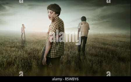 Group of asian scary zombies standing on dry grass field Stock Photo