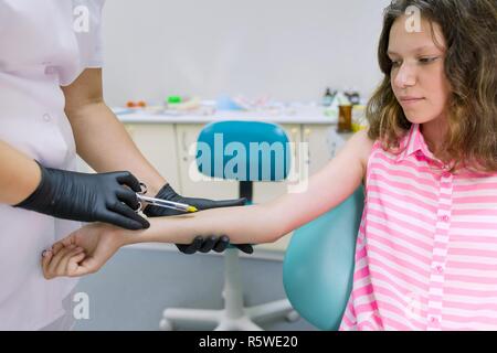 Dentist makes an injection in the hand, checks the reaction of the body to anesthetic preparations. Stock Photo