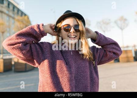 Smiling blonde teen girl 14-16 year old wearing stylish clothes posing  outdoors. Looking at camera. Autumn season Stock Photo - Alamy