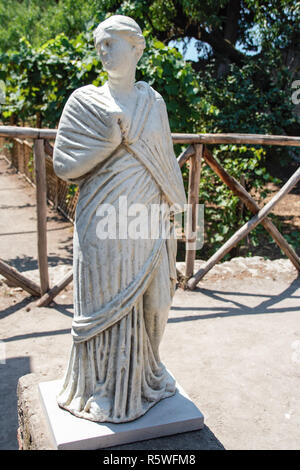 AT POMPEI - ON 06/22/ 2017 - Statue in the backyard of a villa in the  ancient roman town of Pompeii, destroyed by vesuvius eruption in 70 d.c. Stock Photo