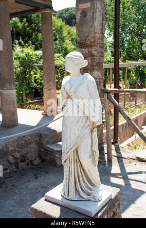 AT POMPEI - ON 06/22/ 2017 - Statue in the backyard of a villa in the  ancient roman town of Pompeii, destroyed by vesuvius eruption in 70 d.c. Stock Photo