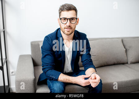 Portrait of a handsome businessman dressed casually sitting on the couch at home Stock Photo
