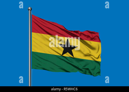 Flag of Ghana waving in the wind against deep blue sky. Ghanaian flag. Stock Photo