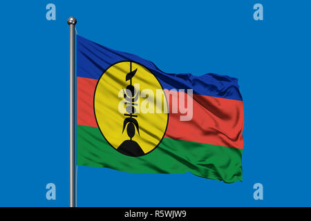 Flag of New Caledonia waving in the wind against deep blue sky. Stock Photo