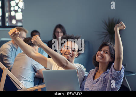 startup business and new mobile technology concept with young multiethnic couple in modern bright office interior working on laptop and tablet computer on new creative project and brainstorming Stock Photo