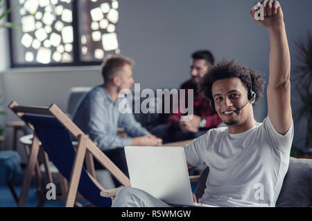 Laughing african american hipster software developer at computer at office of startup company Stock Photo