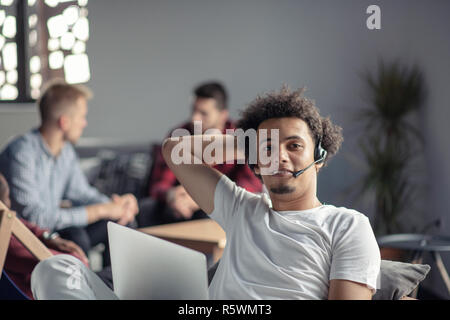 Laughing african american hipster software developer at computer at office of startup company Stock Photo
